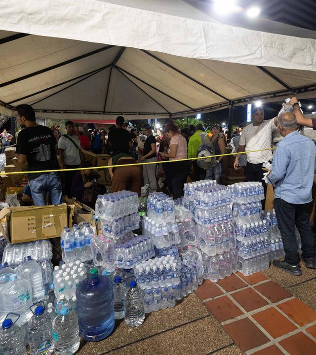 Menschen bringen Wasserspenden nach Erdbeben in Venezuela.