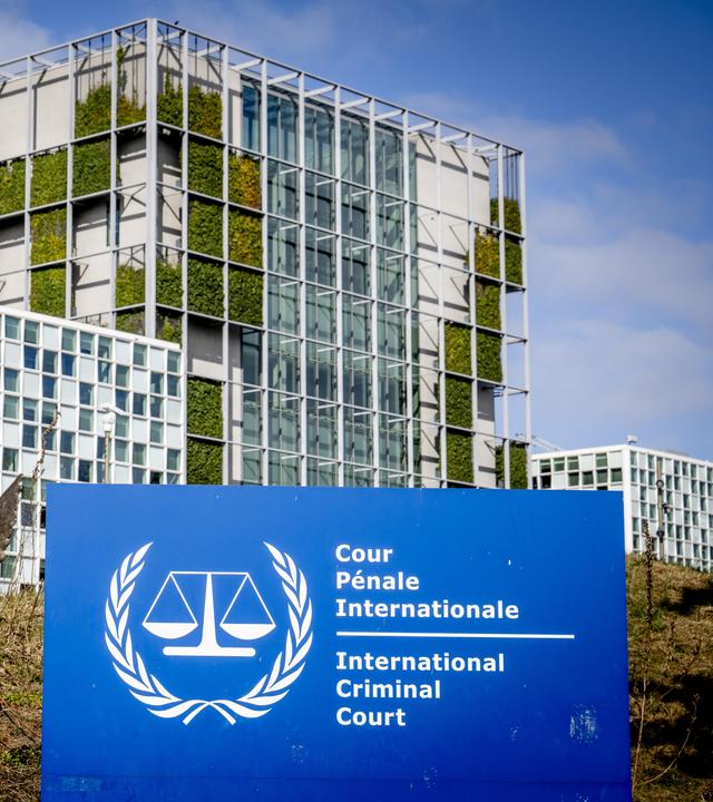 Das Gebäude des internationales Strafgerichtshofes. Im Vordergrund steht en Schild auf dem steht: International Crime Court.