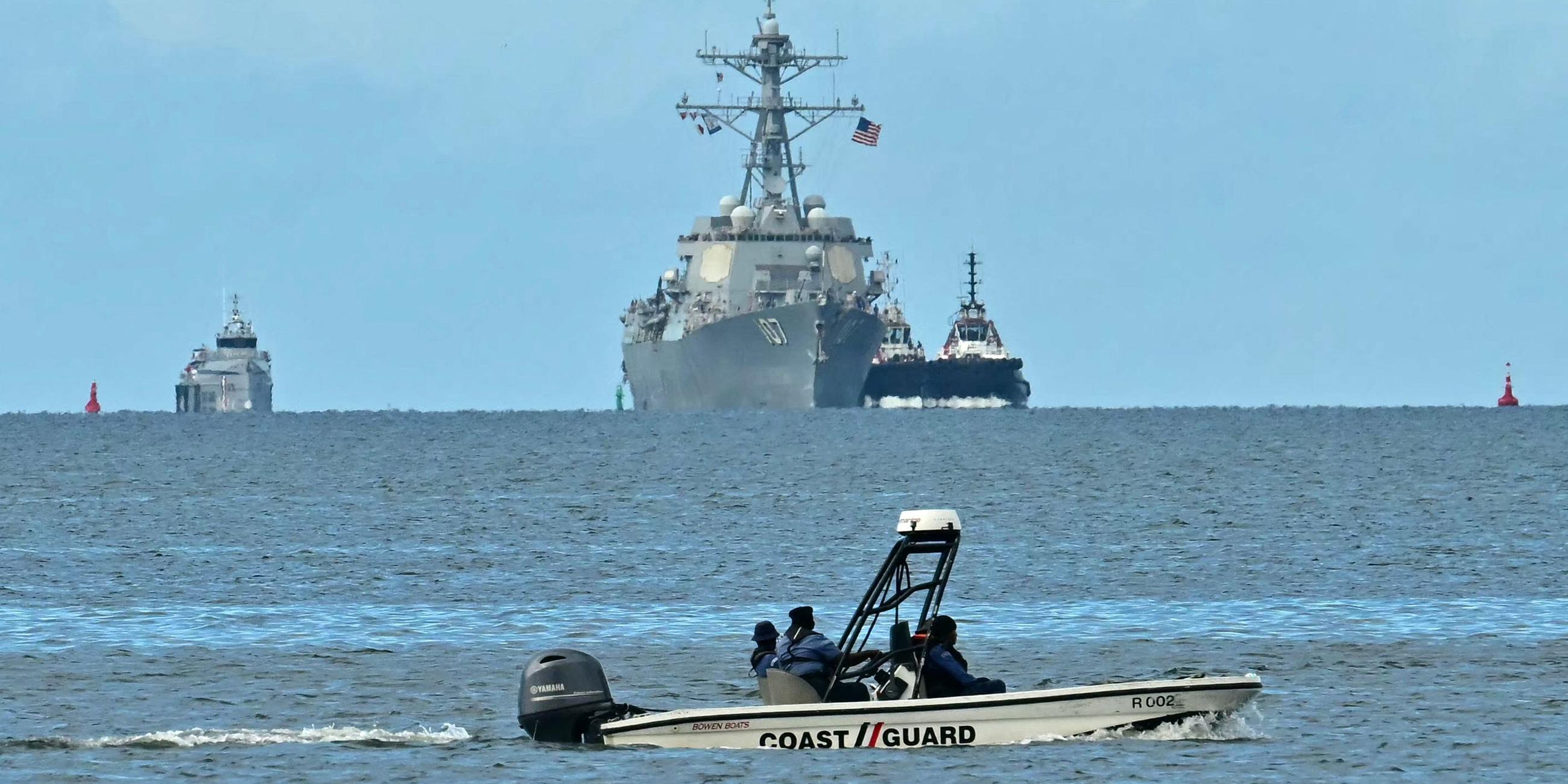 Trinidad und Tobago: Ein kleines Boot steht vor einem US-Kriegsschiff und zwei Begleitbooten.