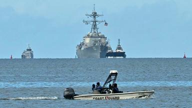 Trinidad und Tobago: Ein kleines Boot steht vor einem US-Kriegsschiff und zwei Begleitbooten.