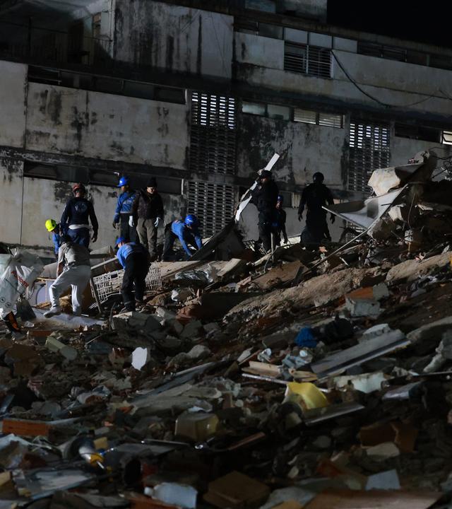 24.06.2026, Venezuela, Caracas: Rettungskräfte durchsuchen nach einem Erdbeben die Trümmer eines eingestürzten Gebäudes.