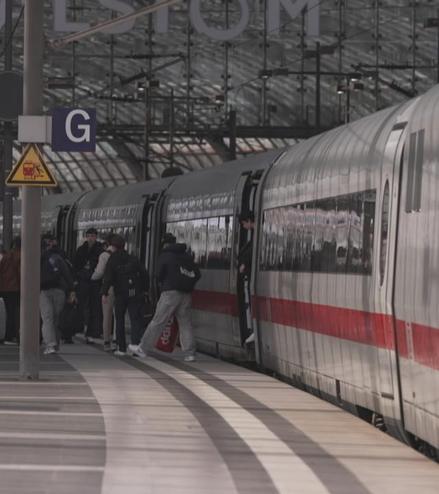 Menschen am Bahnsteig steigen aus ICE ein und aus.