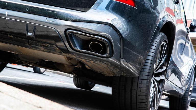 Symbolbild:  Ein dunkler SUV steht auf einem Parkplatz. 