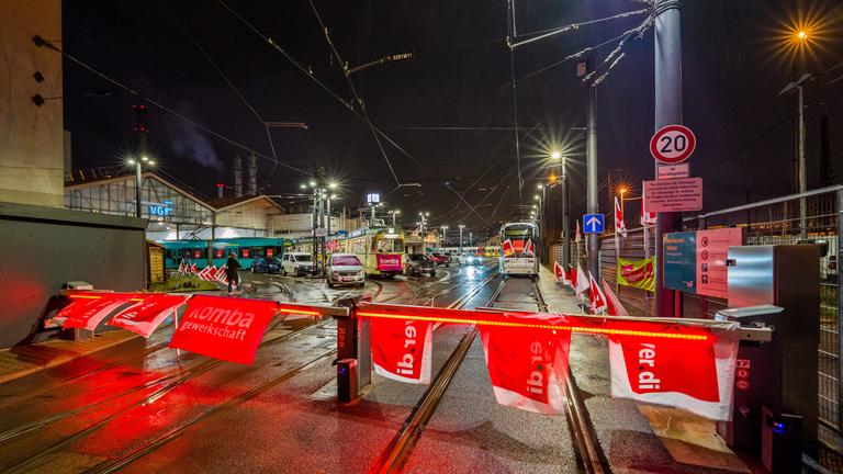 Fahnen der Gewerkschaft «Verdi» sind an den Schranken zum VGF-Betriebshof Gutleut angebracht. Im Hintergrund trägt eine historische Straßenbahn das Banner der Gewerkschaft «Komba». 