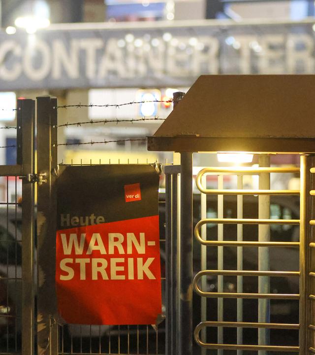 Warnstreik im Hamburger Hafen: An einem Zaun hängt ein Transparent mit der Aufschrift Heute Warnstreik.