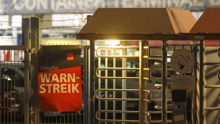 Warnstreik im Hamburger Hafen: An einem Zaun hängt ein Transparent mit der Aufschrift Heute Warnstreik.