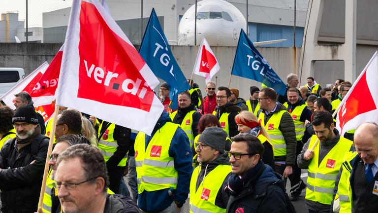 Hessen, Frankfurt/Main: Ein Protestzug von Streikenden zieht mit Bannern und Verdi-Fahnen vom Lufthansa Aviation Center zum Terminal 1.