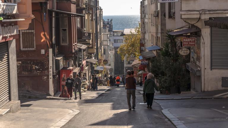Türkei, Istanbul: Menschen gehen im Stadtteil Fatih die Straße entlang. 
