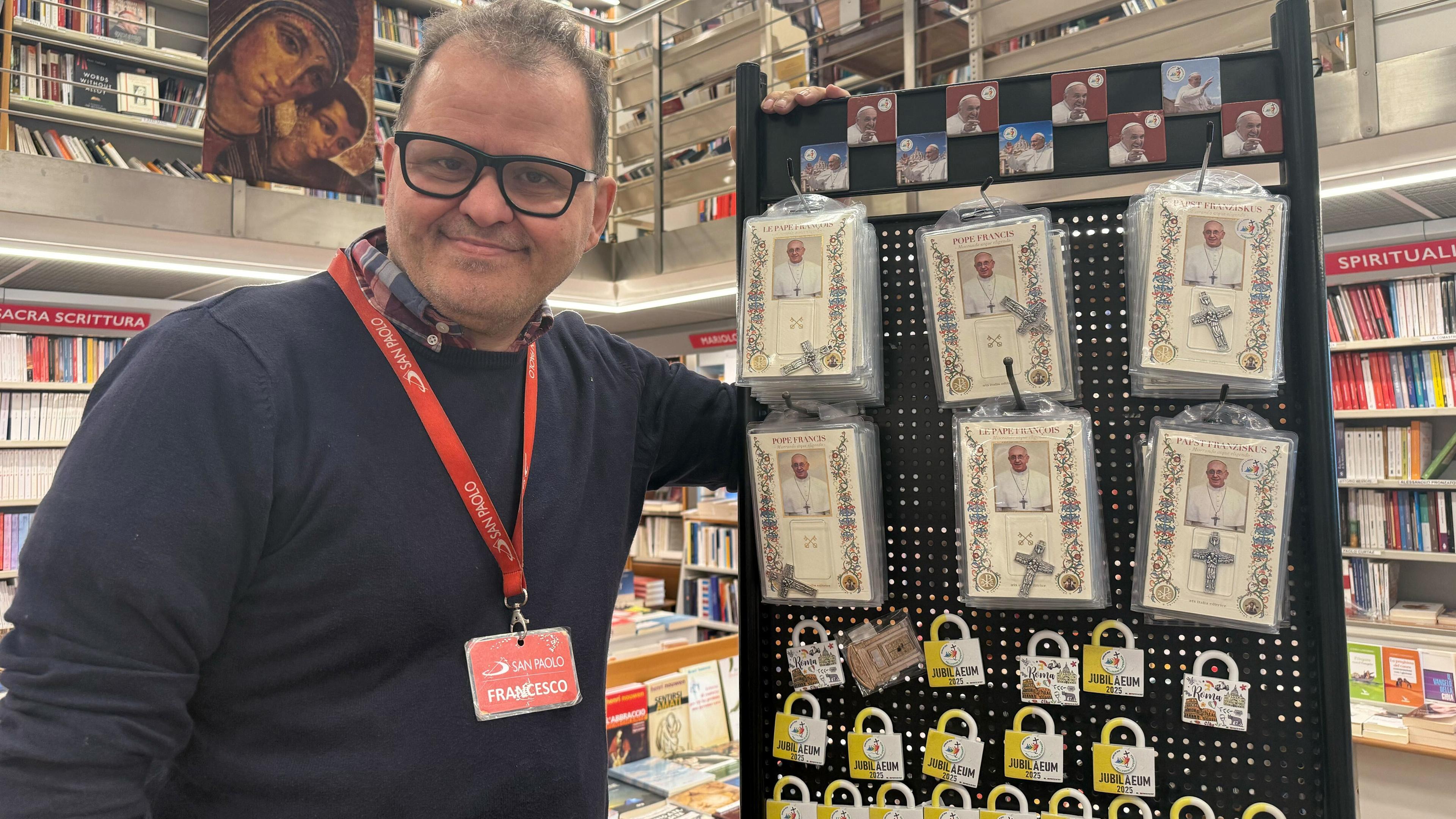 Francesco Trotta, Manager einer Buchhandlung vor dem Vatikan, zeigt Andenken, die er vom verstorbenen Papst Franziskus zum Verkauf anbietet.