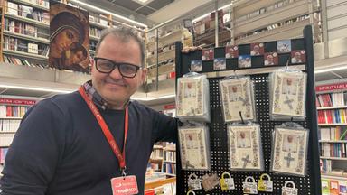 Francesco Trotta, Manager einer Buchhandlung vor dem Vatikan, zeigt Andenken, die er vom verstorbenen Papst Franziskus zum Verkauf anbietet.