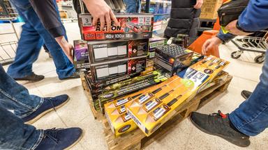 Kunden eines Supermarktes nehmen Feuerwerk direkt von einem Transportwagen.