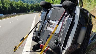 Ein zur Seite gekipptes Fahrzeug liegt auf der B27 an der Unfallstelle am Straßenrand. 