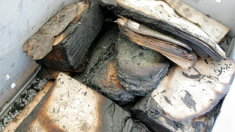 Verkohlte Buchfragmente liegen in einer Transportkiste im Zentrum für Bucherhaltung (ZFB) in Leipzig, Archivbild