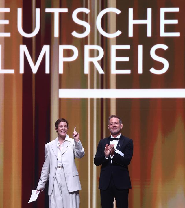29.05.2026, Berlin: Vicky Krieps (l), Schauspielerin und Präsidentin der Deutschen Filmakademie, und Florian Gallenberger, Regisseur und Präsident der Deutschen Filmakademie, eröffnen die Verleihung des Deutschen Filmpreises im Palais am Funkturm.