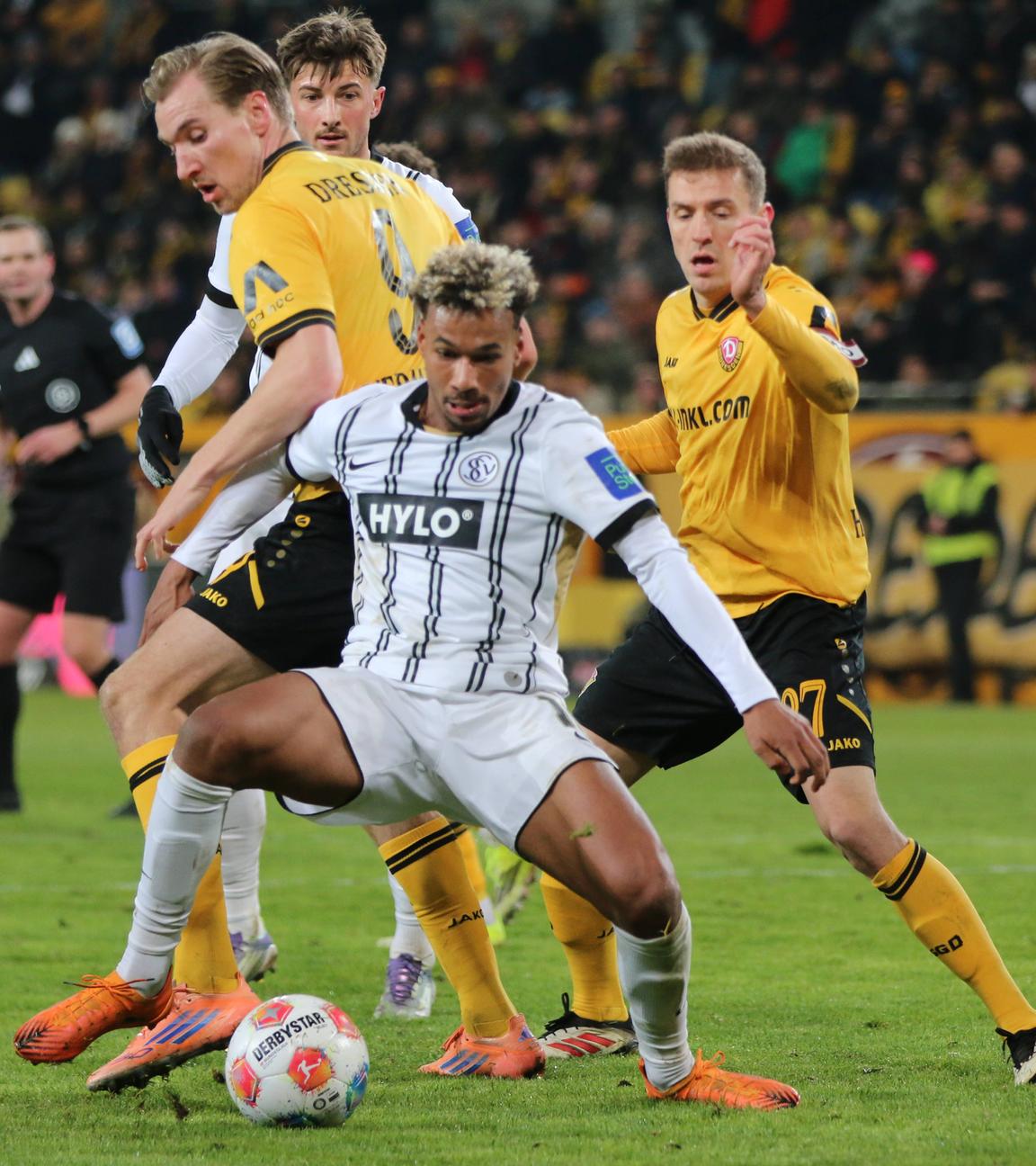 Verls offensiver Mittelfeldspieler Bambasé Conté wird im Zweikampf um den Ball von Dresdens Stürmer Vincent Vermeij von hinten bedrängt 