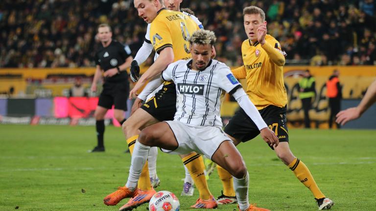 Verls offensiver Mittelfeldspieler Bambasé Conté wird im Zweikampf um den Ball von Dresdens Stürmer Vincent Vermeij von hinten bedrängt 