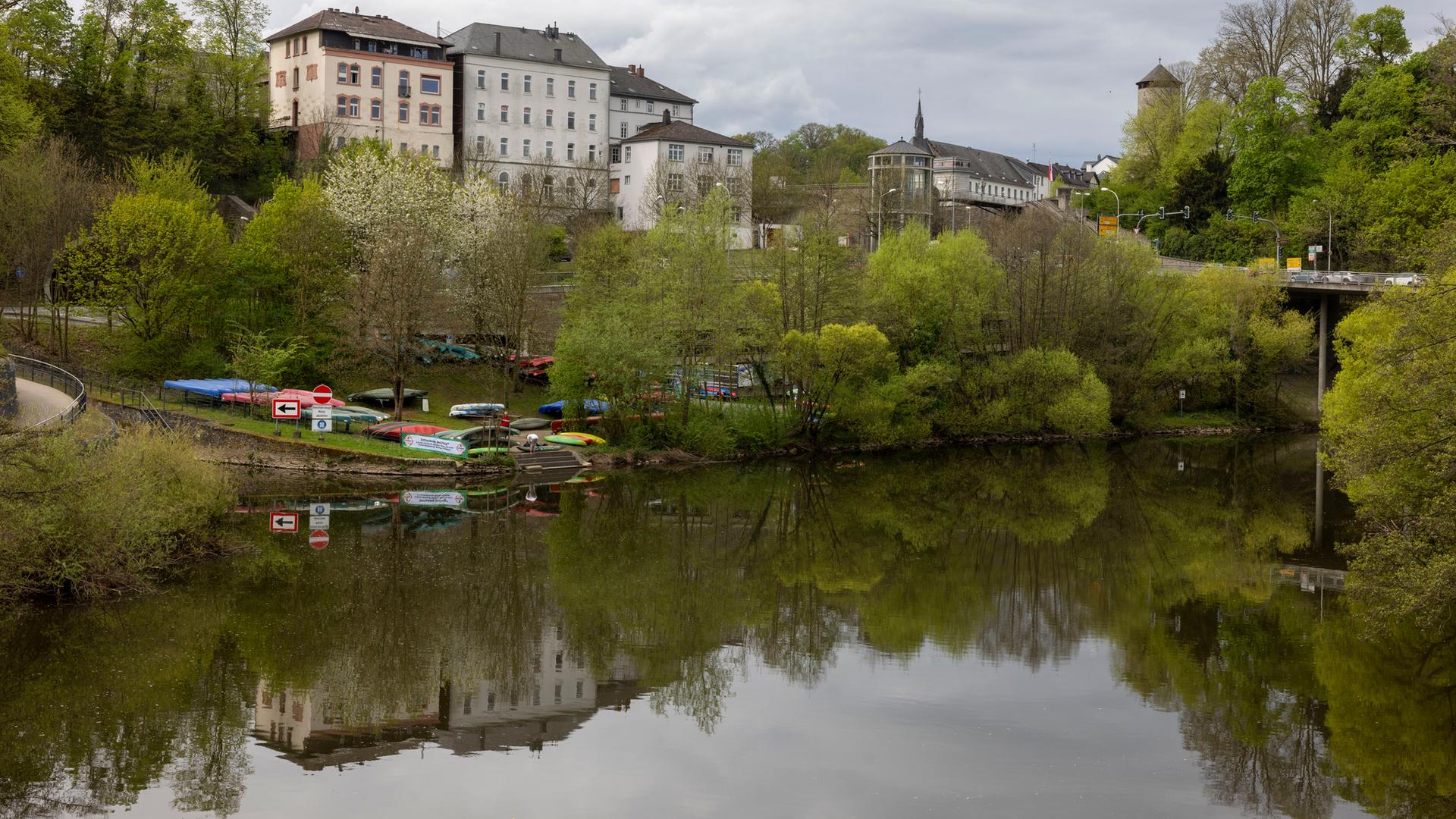 Hessen, Weilburg: Kanus liegen an der Lahn - im Hintergrund ist Schloss Weilburg zu sehen.