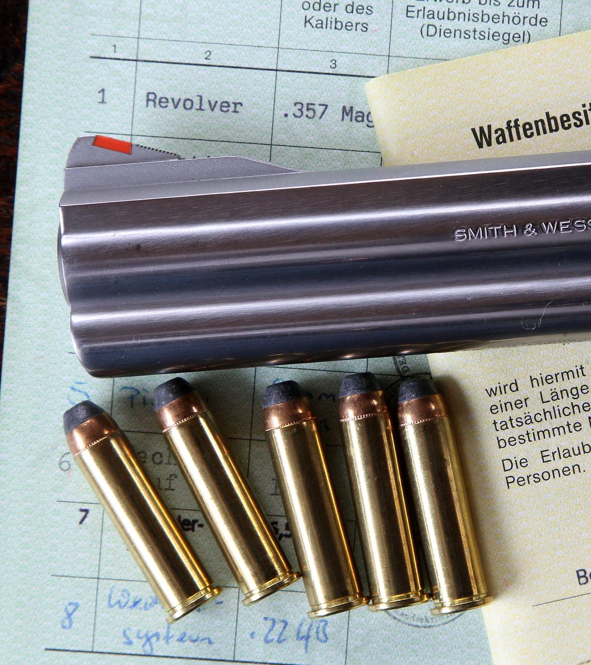 Ein Revolver mit Patronen liegt auf einem Schießstand auf einem Tisch.