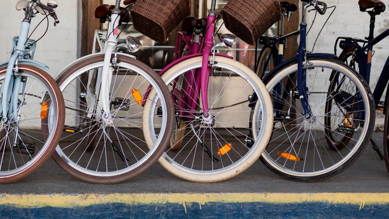 Mehrere Fahrräder stehen sind auf einem Gehweg.