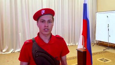 Denis in russischer Uniform  neben einer russoschen Flagge 