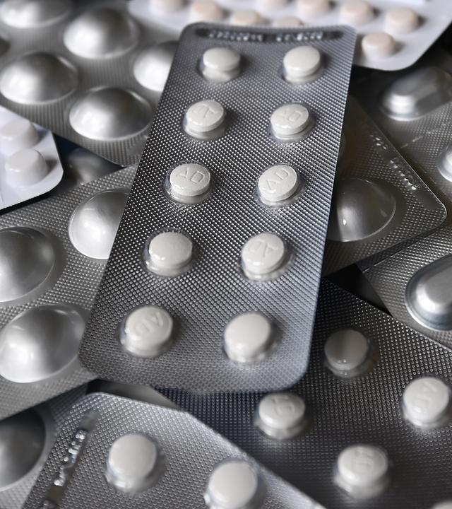 Nahaufnahme von Medikamenten in Blisterpackungen, die übereinander angeordnet sind.