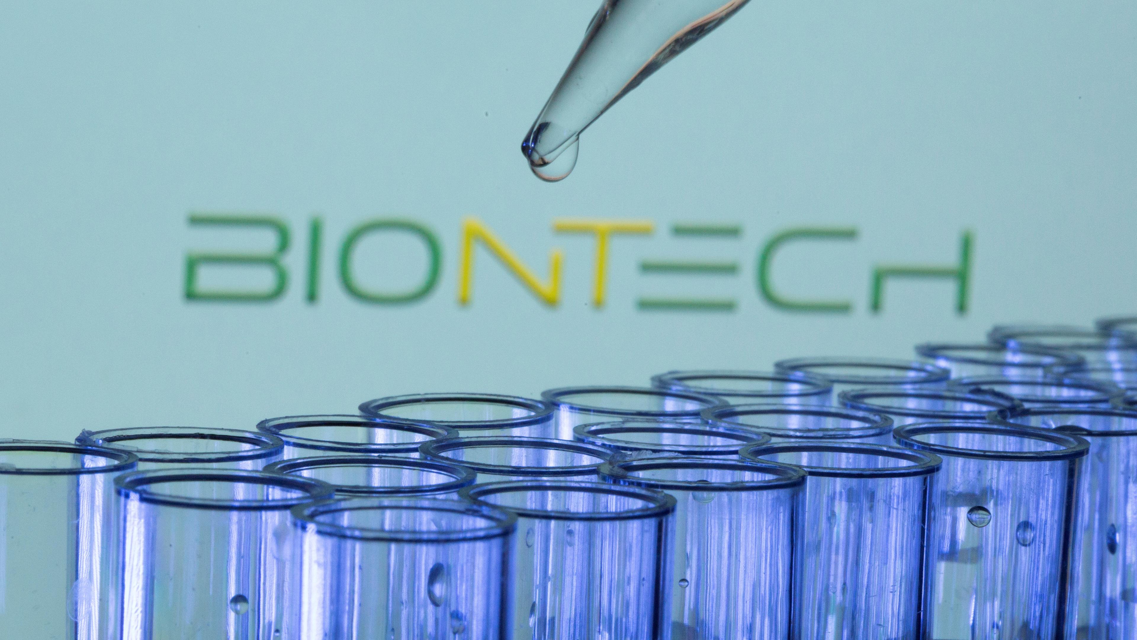 Teströhrchen vor Biontech-Logo