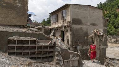Anwohner versuchen in den beschädigten Häusern nach Sturzfluten, entlang des Ufers des Trishuli-Flusses im Distrikt Dhading, Nepal, am 30.08.2026 persönliche Gegenstände zu retten. 
