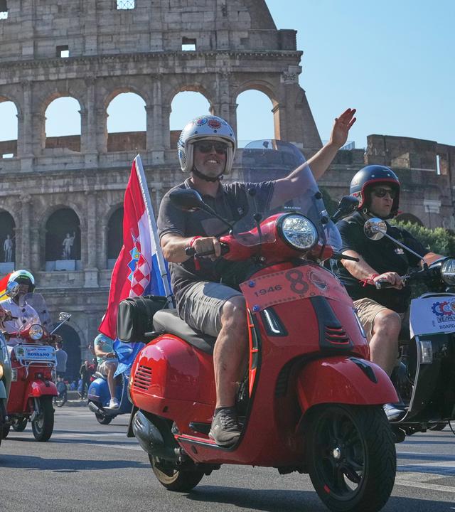 Vespa-Fans fahren anlässlich der Feierlichkeiten zum 80-jährigen Jubiläum des Vespa-Rollers am Samstag, dem 27. Juni 2026, in Rom vor dem Kolosseum vorbei.