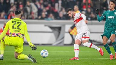 Stuttgarts Torjäger Deniz Undav (Mitte) gegen Torwart Nediljko Labrovic (l.) und Dimitris Giannoulis vom FC Augsburg