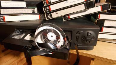 Ein VHS- rekorder, Videokassetten und jede Menge Bandsalat