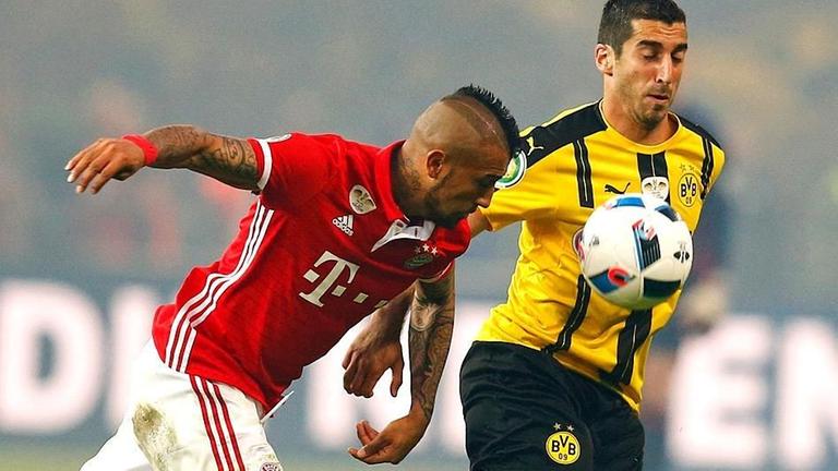 Bayerns Arturo Vidal (li.) im Duell mit Dortmunds Henrikh Mkhitaryan (re.).
