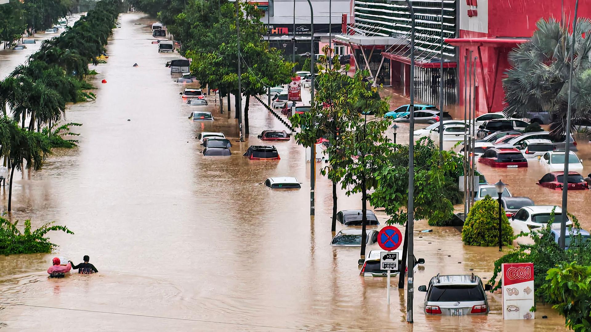 Vietnam, Küstenprovinz Khanh Hoa: Menschen suchen einen Weg durch überflutete Straßen.