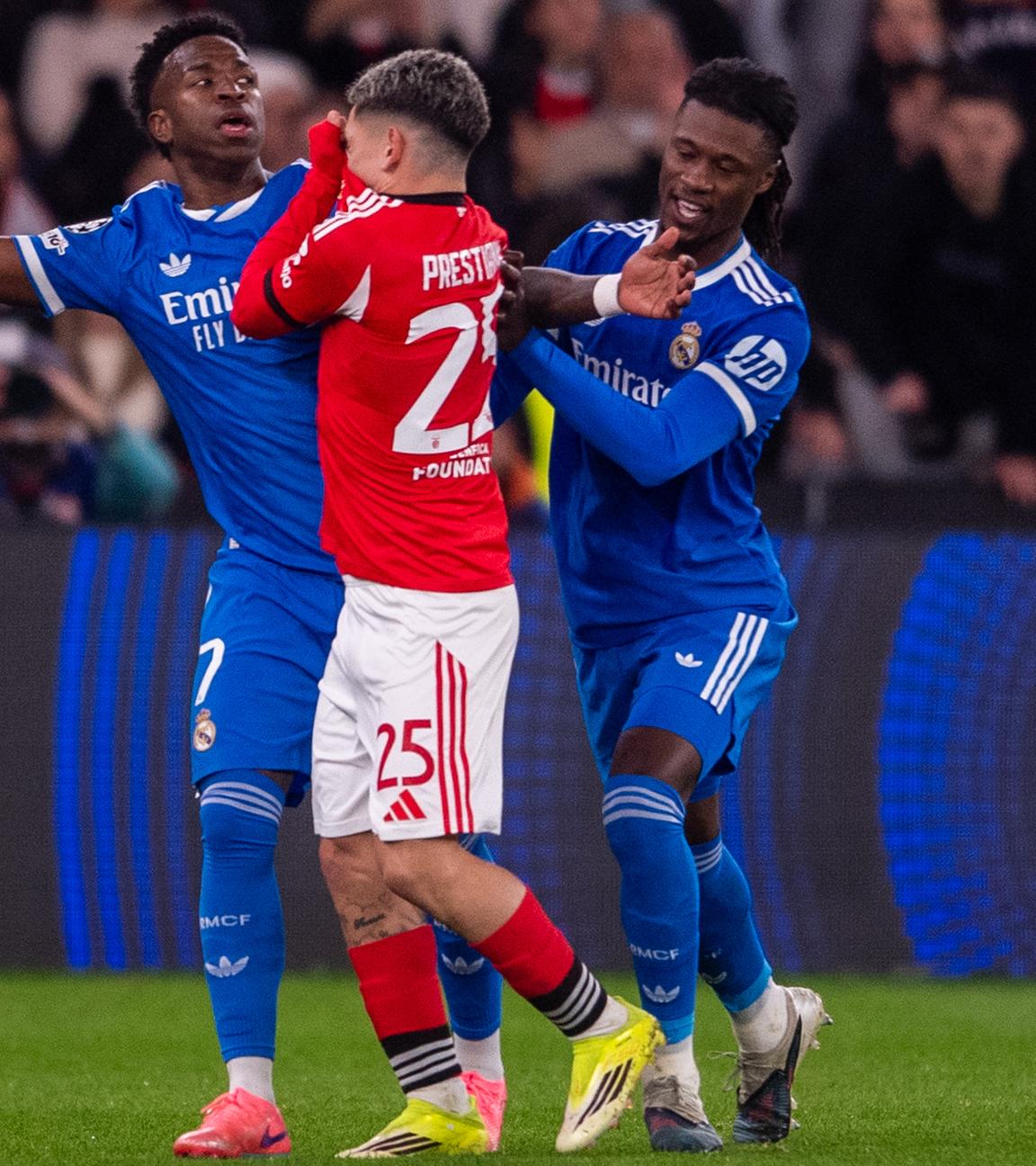 Gianluca Prestianni (Benfica Lissabon, Mitte) hält sich das Trikot vor den Mund, Vinicius Junior (Real Madrid, links) breitet die Arme aus.