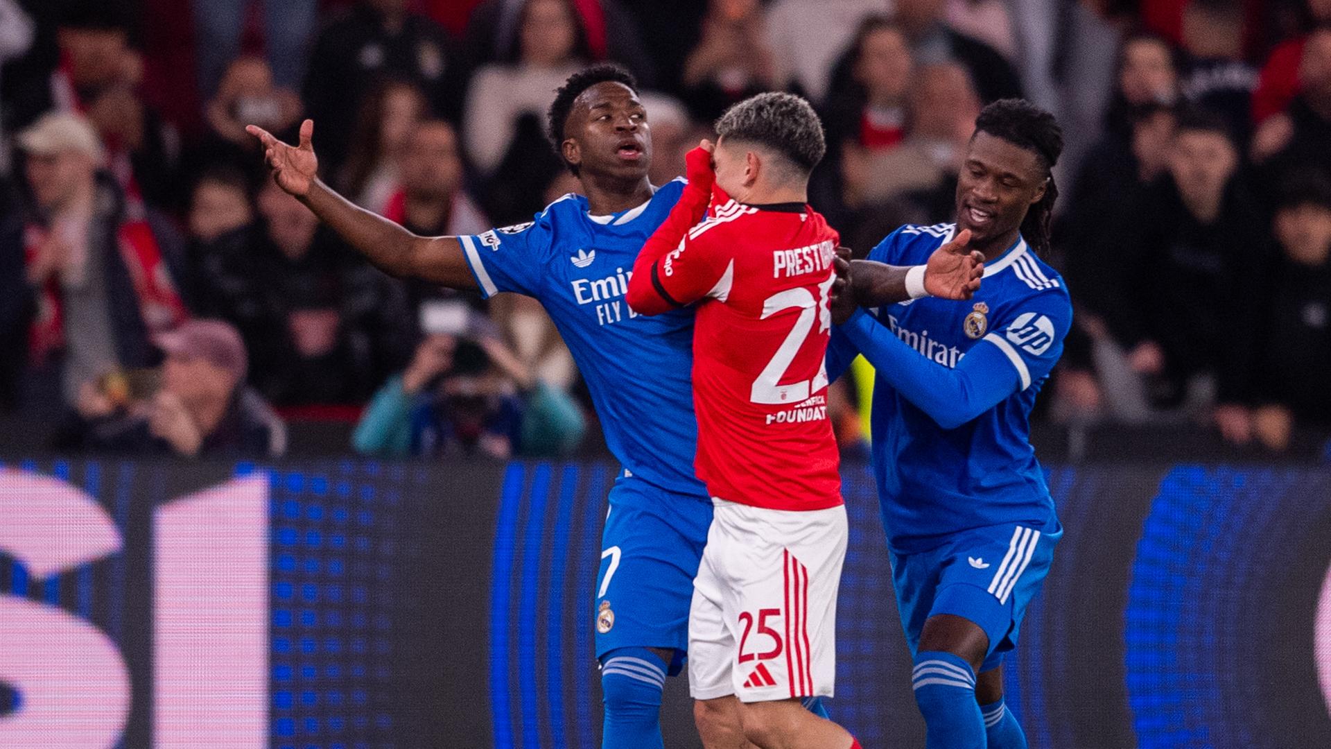 Gianluca Prestianni (Benfica Lissabon, Mitte) hält sich das Trikot vor den Mund, Vinicius Junior (Real Madrid, links) breitet die Arme aus.