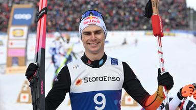 Vinzenz Geiger steht auf einer Skipiste und schaut lächelnd in die Kamera