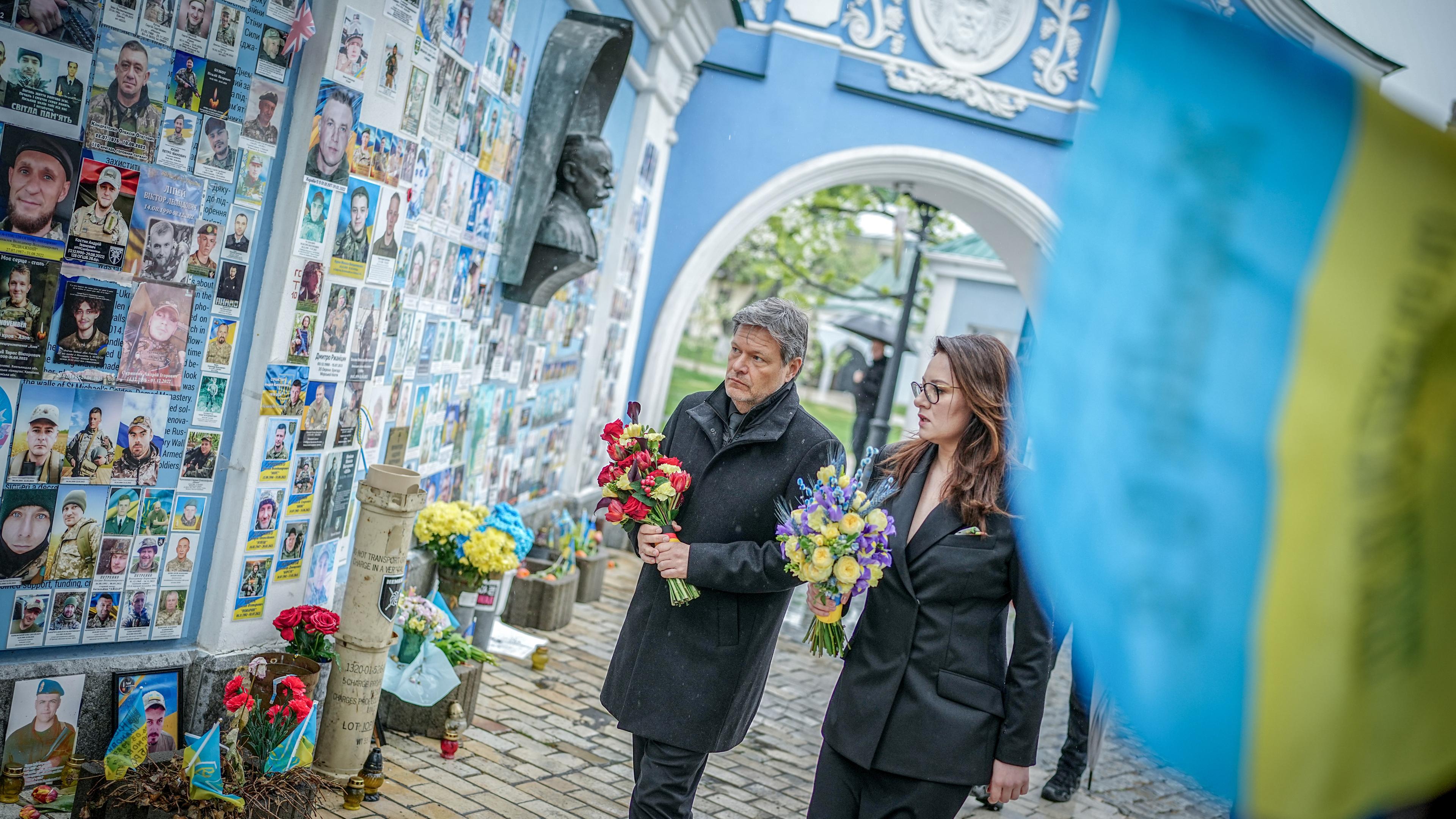 Robert Habeck (Bündnis 90/Die Grünen, l), Bundesminister für Wirtschaft und Klimaschutz, legt an der Gedenkmauer füdie im Krieg gefallenen Soldaten Blumen nieder. 