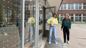 Zwei Frauen blicken auf eine Folie mit weißen Punkten, die an einer Berliner Grundschule zum Vogelschutz angebracht wurde.