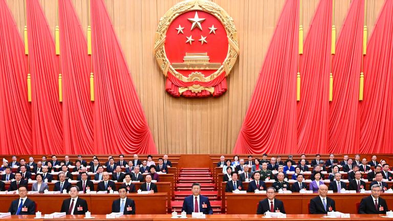 Der 14. Nationale Volkskongress (NVK) eröffnete seine vierte Sitzung am 5. März 2026 in der Großen Halle des Volkes in Peking, der Hauptstadt Chinas. Xi Jinping und andere Partei- und Staatsführer, darunter Li Qiang, Wang Huning, Cai Qi, Ding Xuexiang, Li Xi und Han Zheng, nahmen am Rednerpult Platz.