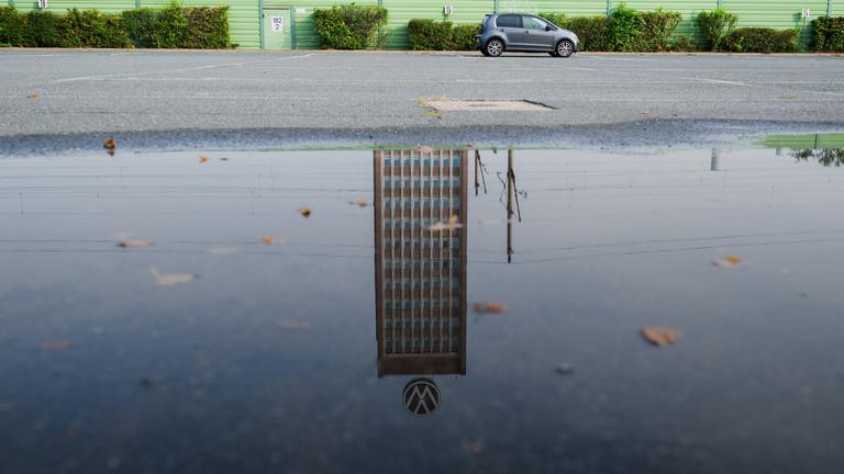 Symbolbild:  Das Markenhochhaus am VW-Stammwerk spiegelt sich in einer Pfütze. 