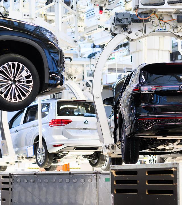 Symbolbild: Neuwagen Volkswagen Tayron, Tiguan und Touran schweben durch das VW Stammwerk.