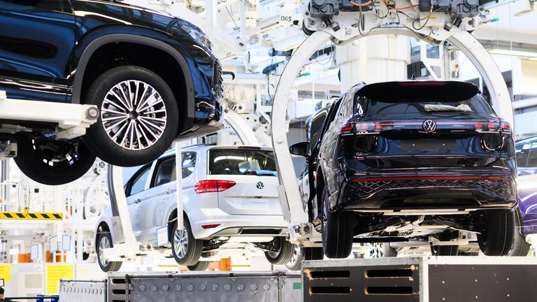 Symbolbild: Neuwagen Volkswagen Tayron, Tiguan und Touran schweben durch das VW Stammwerk.