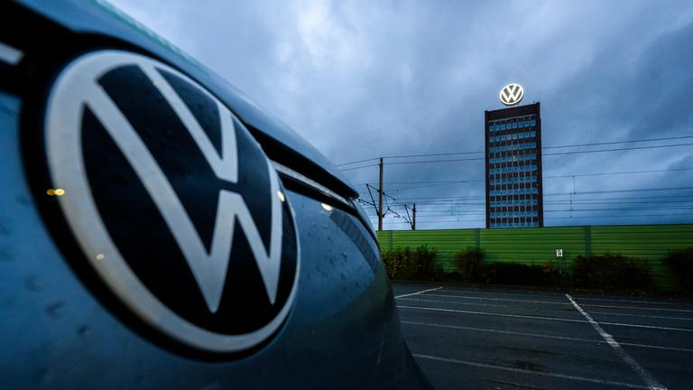 Niedersachsen, Wolfsburg: Ein Volkswagen parkt vor dem Markenhochhaus von Volkswagen am Gelände vom VW Stammwerk.