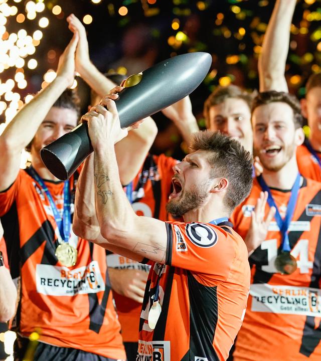Berlins Ruben Schott hält den Siegerpokal in den Händen. 
