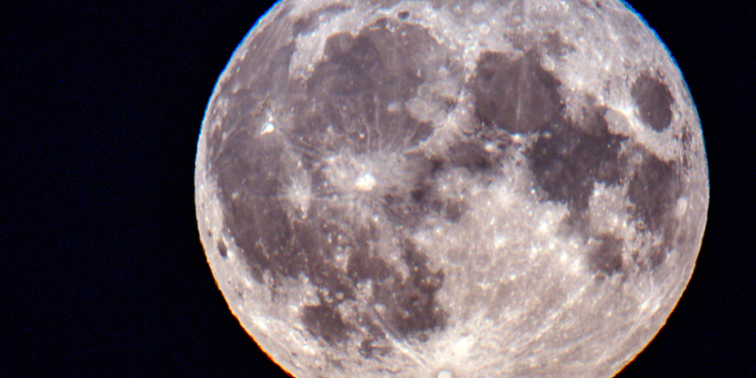 Mecklenburg-Vorpopmmern, Schwerin: Der Vollmond geht über dem Schweriner Schloss auf. 