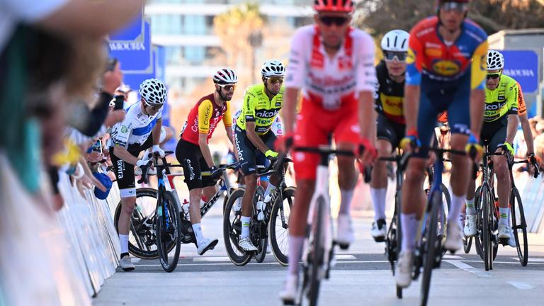 Radsportler sind falsch abgebogen und klettern über die Absperrung zum richtigen Weg beim Volta Algarve.