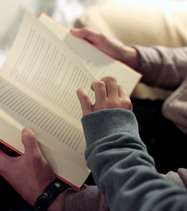 Eine Mutter liest ihrer Tochter aus einem Buch vor.
