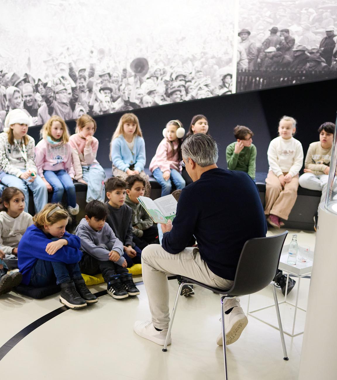 Manuel Neukirchner, Direktor des Deutschen Fußballmuseums, liesst im Deutschen Fußballmuseum Schulkindern vor.