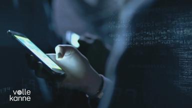 Person hält ein Handy in der Hand (dunkle Aufnahme).