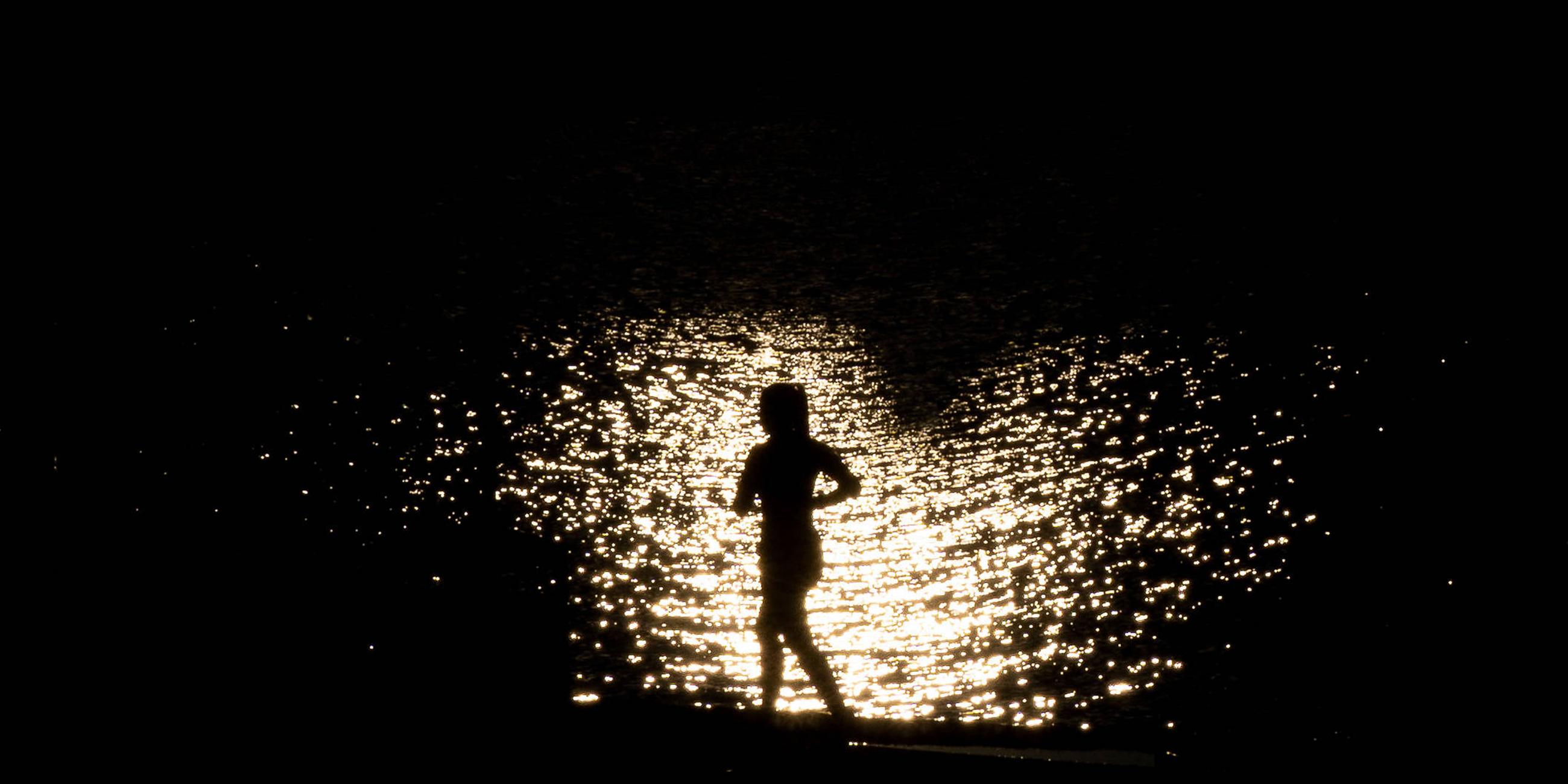 Eine Silhouette einer joggenden Frau im Sonnenuntergang am 21.07.2025 in Frankfurt am Main.