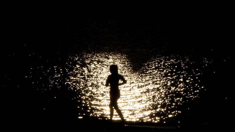 Eine Silhouette einer joggenden Frau im Sonnenuntergang am 21.07.2025 in Frankfurt am Main.